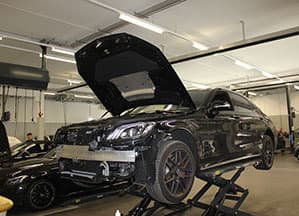 Mercedes-AMG met geopende motorkap op de hefbrug